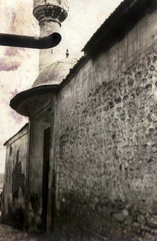 Harim duvarı ve minarenin kaidesi; yosunlu taş örgüsü yapının yaşını yansıtıyor.